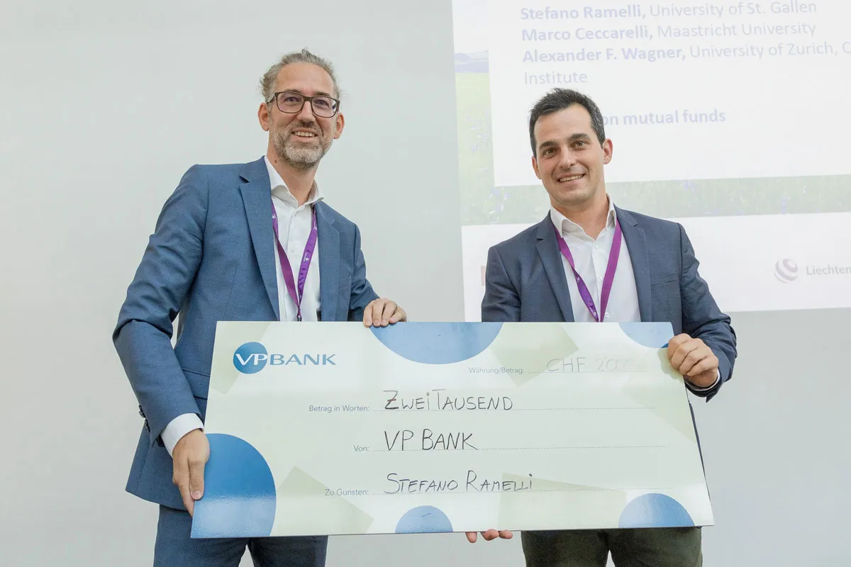 Bernd Hartmann (VP Bank) presents the Best Paper Award to the winner, Stefano Ramelli (University of St. Gallen), Photo: University of Liechtenstein, Vaduz. Liechtenstein Workshop of Sustainable Finance & Award. Photo: ©Paul J. Trummer  VP Bank Best Paper Award